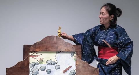 Woman wearing kimono, telling a story with paper screens