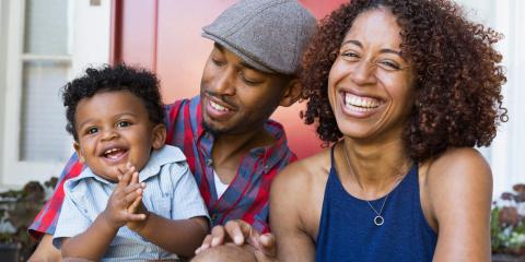 Smiling mom, dad, and child who is sitting on dad's lap