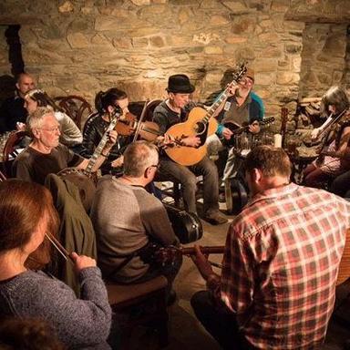 A group of people singing. One holds a guitar.