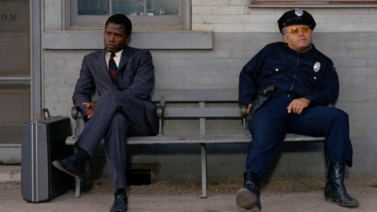 Image from "In the Heat of the Night". Sidney Poitier as Virgil Tibbs sits next to Rod Steiger as Bill Gillespie.