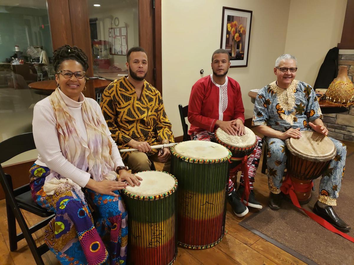 Four members of the Ibeji Drum Circle seated at drums.